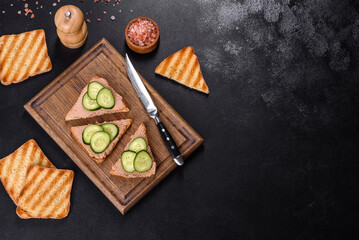 Fototapeta na wymiar Delicious fresh sandwich with chicken liver pate with crispy toast, butter and cucumber