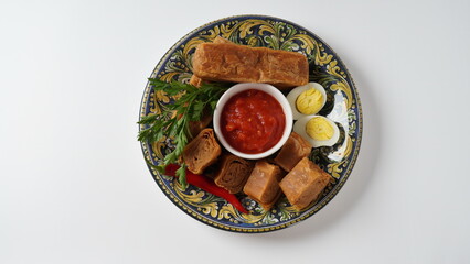 Jachnun or Jahnun, Yemenite Jewish pastry, served with fresh grated tomato and boiled egg and Zhug,  originating from the Adeni Jews, and traditionally served on Shabbat morning in Israel.