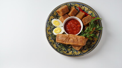 Jachnun or Jahnun, Yemenite Jewish pastry, served with fresh grated tomato and boiled egg and Zhug,  originating from the Adeni Jews, and traditionally served on Shabbat morning in Israel.