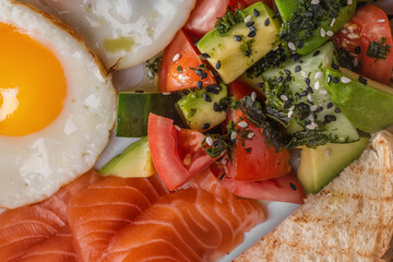 Fried toast with salmon slices, avocado, cucumbers, sesame seeds