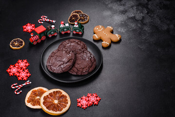 Delicious fresh chocolate biscuits on a dark concrete background with Christmas toys