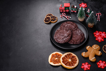 Delicious fresh chocolate biscuits on a dark concrete background with Christmas toys