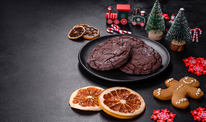 Delicious fresh chocolate biscuits on a dark concrete background with Christmas toys