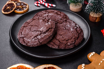 Delicious fresh chocolate biscuits on a dark concrete background with Christmas toys