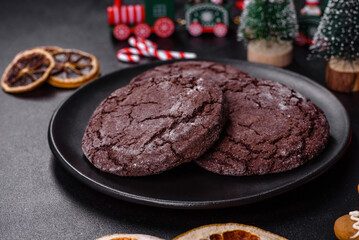 Delicious fresh chocolate biscuits on a dark concrete background with Christmas toys