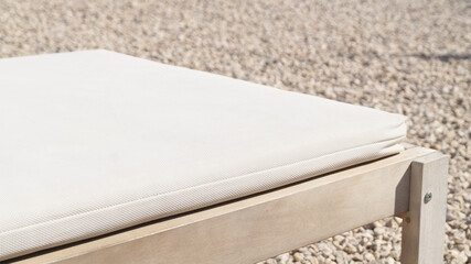 White deckchair in the summer sun. Holiday background. White deckchair with bouquet of white flowers. Summer Vacation. Space for text. Wooden chair for sunbathing.