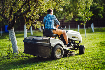 Industry details - portrait of gardener mowing lawn, cutting grass in garden