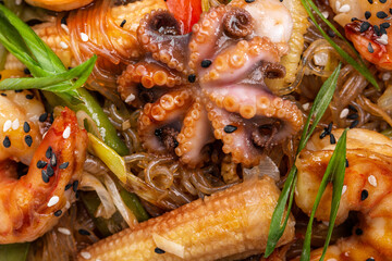 Rice noodles with onions, shrimps, squid, corn, sesame seeds,