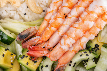 Salad with shrimps, rice, avocado, lettuce, sesame seeds and cucumbers