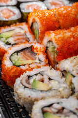 Rolls with salmon, cucumber, avocado, tobiko caviar and eel