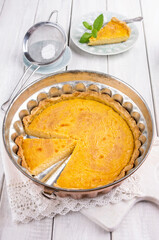 Traditional French tart au citron cake served as close-up copper backing form on a wooden table