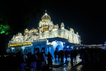 Gurudwara Bangla Sahib illuminated with lights on the eve of Guru Nanak Jayanti in New Delhi, India	 - obrazy, fototapety, plakaty