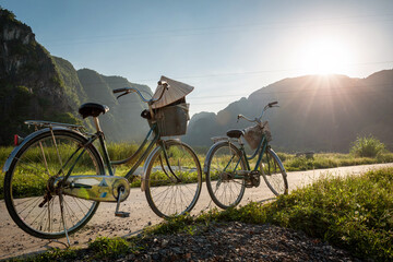 Paseo al atardecer en bicicleta por los arrozales de Ninh Binh, Vietnam - obrazy, fototapety, plakaty
