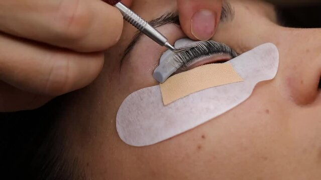 Close-up of a woman's face during an eyebrow thickening and eyelash lamination treatment. 