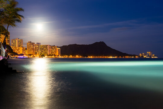 Beautiful night view of sky, diamondhead, beach, and moon in Waikiki beach, Honolulu, Hawaii