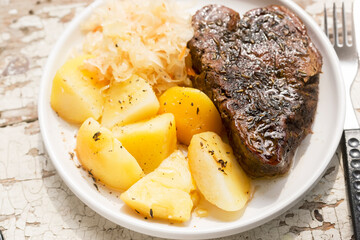 Beef steak with fried potatoes and cabbage and carrot slaw
