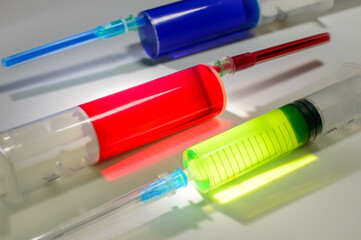 Tree medical syringes with colored paint of different colors on a white background. Vaccination...