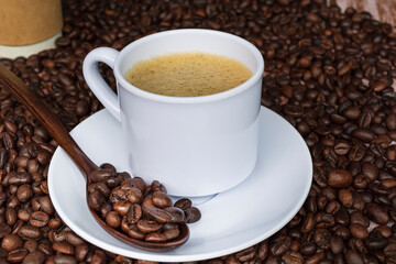 Cup of coffee on coffee beans background.
