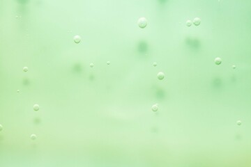 Cosmetic green lotion transparent gel drops texture background