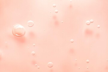 Cosmetic pink lotion transparent gel drops texture background