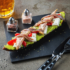 Traditional Spanish breakfast. Tostada with different toppings on a dark background