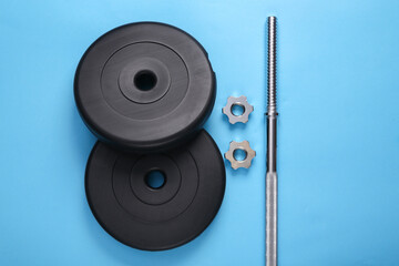 Disassembled barbell on a blue background. Bodybuilding and fitness. Top view