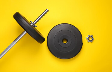 Bodybuilding and fitness. Barbell on a yellow background. Top view