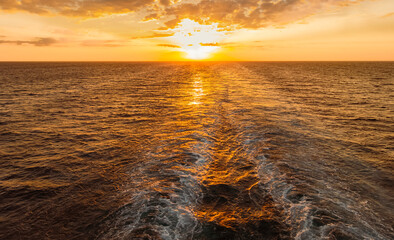 Coucher de soleil dans le sillage d'un navire de croisière.