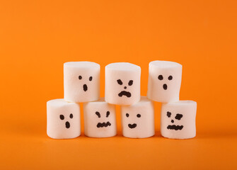 Halloween marshmallows with face on orange background