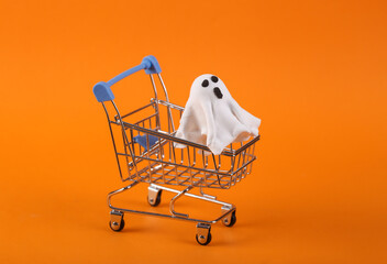 Mini shopping cart with a ghost on an orange background. Halloween sale
