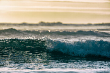 waves breaking on the beach at sunset background