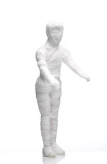 Mummy doll wrapped in bandages on white background. Minimal halloween concept