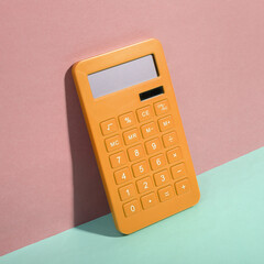 yellow Calculator on blue-pink background. Minimalism. Trendy shadow. Creative layout