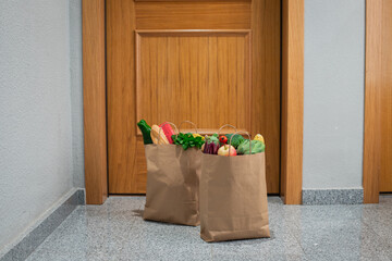 Food shopping bags stand at the door of the house or apartment. Vegetables and fruits delivery...