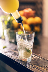 Bartender pouring syrup into cocktail glass