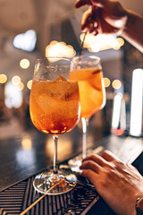 Barman mixing aperol spritz cocktail