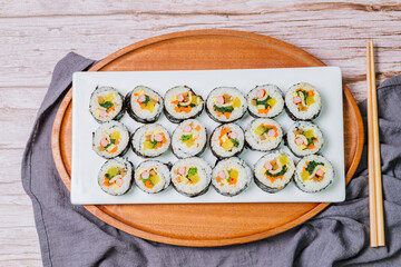 Korean food Gimbap : Rice seasoned with salt and sesame oil and rolled up in a sheet of roasted gim (dried laver) with spinach, carrots, and pickled white radish. The long roll is sliced and served in