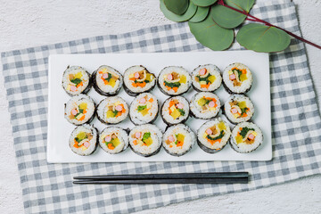Korean food Gimbap : Rice seasoned with salt and sesame oil and rolled up in a sheet of roasted gim (dried laver) with spinach, carrots, and pickled white radish. The long roll is sliced and served in