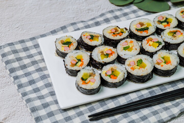 Korean food Gimbap : Rice seasoned with salt and sesame oil and rolled up in a sheet of roasted gim (dried laver) with spinach, carrots, and pickled white radish. The long roll is sliced and served in