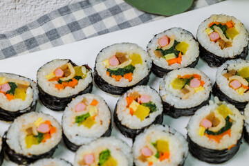 Korean food Gimbap : Rice seasoned with salt and sesame oil and rolled up in a sheet of roasted gim (dried laver) with spinach, carrots, and pickled white radish. The long roll is sliced and served in