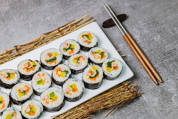 Korean food Gimbap : Rice seasoned with salt and sesame oil and rolled up in a sheet of roasted gim (dried laver) with spinach, carrots, and pickled white radish. The long roll is sliced and served in