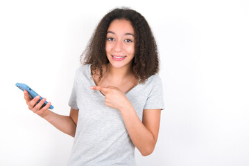 Naklejka premium Portrait cute astonished young beautiful girl with afro hairstyle wearing grey t-shirt over white wall impressed unbelievable unexpected incredible notification advice