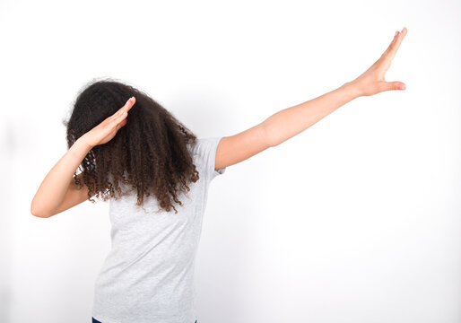 Photo of funky young beautiful girl with afro hairstyle wearing grey t-shirt over white wall show disco move dab