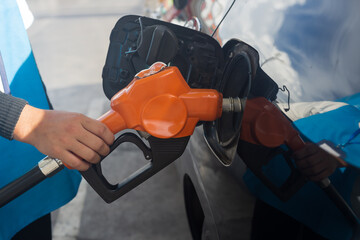 Grey car at gas station being filled with fuel on thailand