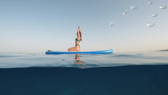 Girl awakens in the morning on the stand up paddle in the sea