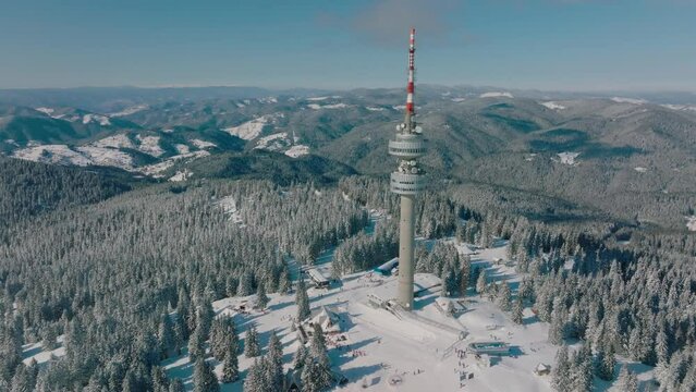 4K Aerial winter view of Rhodope Mountains and Snezhanka tower near resort of Pamporovo, Smolyan Region, Bulgaria