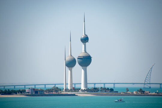 The Kuwait Towers are a group of three thin towers in Kuwait City, standing on a promontory into the Persian Gulf with a TGI Fridays in the foreground