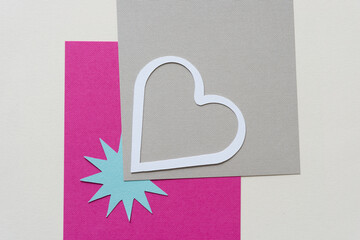 paper heart and starburst on gray and pink