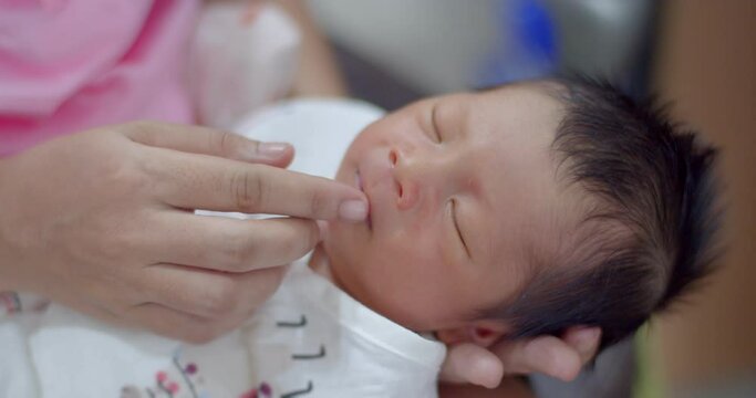 With the warmth and the mother's loving, hand mother smeared Vaseline on an infant's mouth to prevent dry mouth.