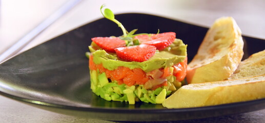 Lachstatar mit Avocadocreme, garniert mit Erdbeeren  dazu Baguette